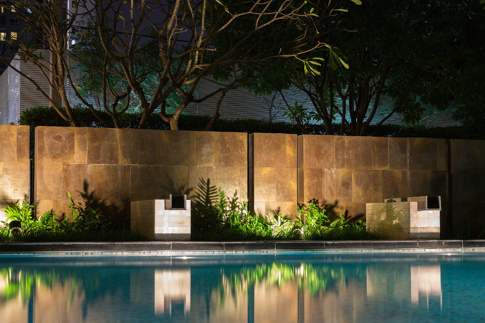 Romantyczne wieczorne oświetlenie nastrojowe rzuca cienie na romantyczną scenerię przy basenie. Ten luksusowy dom ma jedne z najlepszych ogrodów i tropikalnej flory na świecie.